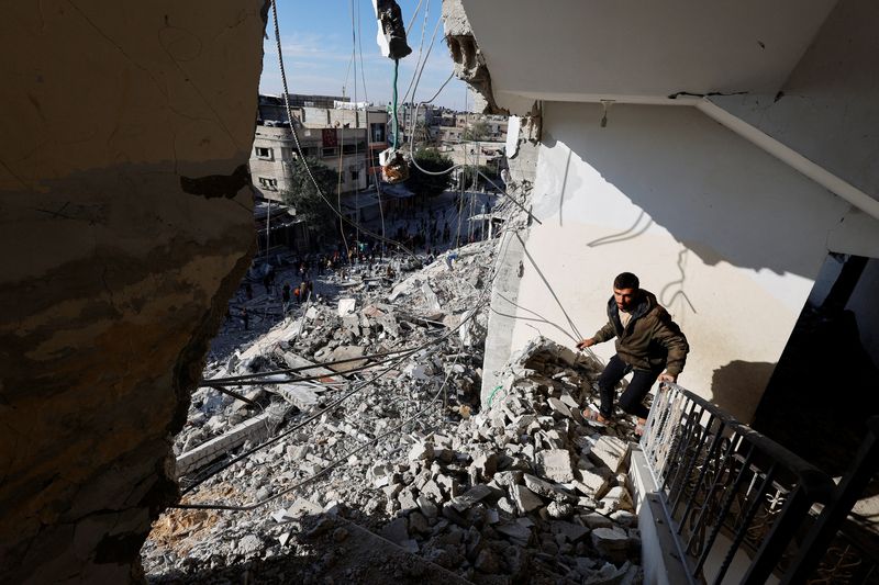 &copy; Reuters. FILE PHOTO: A Palestinian man walks through the rubble of a building damaged in an Israeli air strike, amid the ongoing conflict between Israel and the Palestinian Islamist group Hamas, in Rafah, in the southern Gaza Strip March 9, 2024. REUTERS/Mohammed 