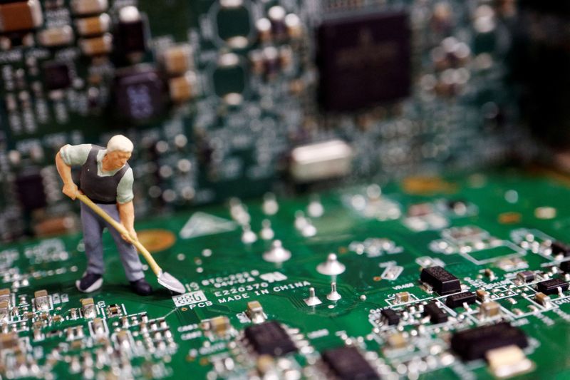 © Reuters. A worker miniature is placed among printed circuit boards with semiconductor chips, in this illustration picture taken July 5, 2023. REUTERS/Florence Lo/Illustration/File Photo