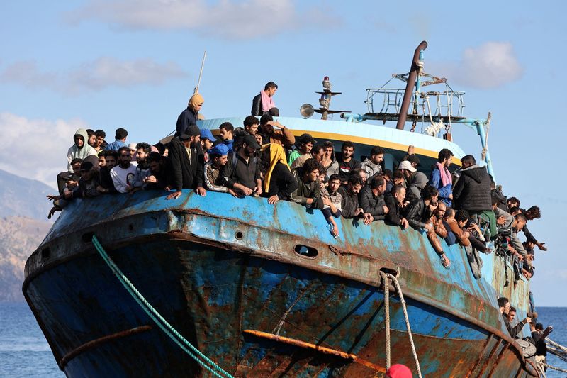 &copy; Reuters. مهاجرون يجلسون على متن قارب صيد بميناء عقب عملية إنقاذهم قبالة جزيرة كريت باليونان في صورة من أرشيف رويترز .   