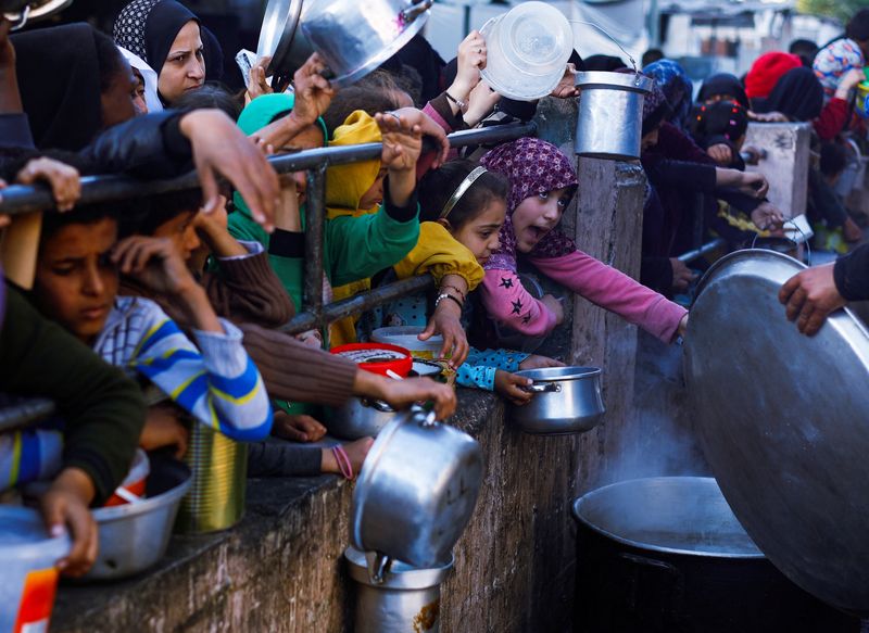 &copy; Reuters. Palestinian children wait to receive food during the Muslim holy fasting month of Ramadan, as the conflict between Israel and Hamas continues, in Rafah, in the southern Gaza Strip March 13, 2024. REUTERS/Mohammed Salem