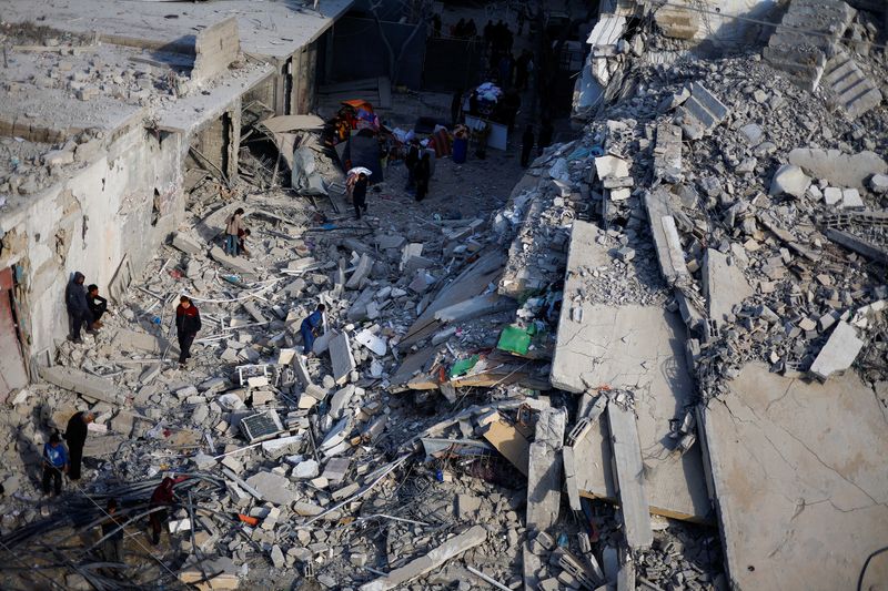 &copy; Reuters. فلسطينيون يتفقدون آثار الدمار التي لحقت بأحد المباني السكنية جراء غارة إسرائيلية على رفح جنوبي غزة في التاسع من مارس آذار 2024 . تصوير: محمد سا