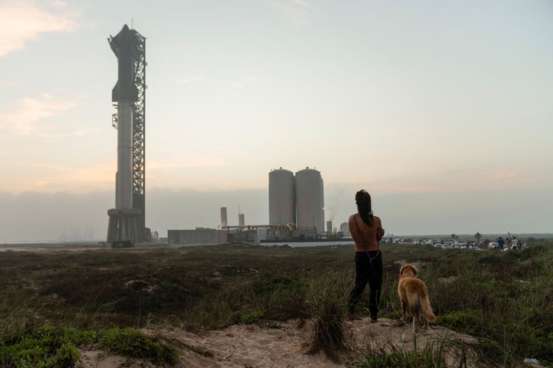 &copy; Reuters. A spectator, with his dog, looks on as SpaceX's next-generation Starship spacecraft atop its powerful Super Heavy rocket is prepared for a third launch from the company's Boca Chica launchpad on an uncrewed test flight, near Brownsville, Texas, U.S. March