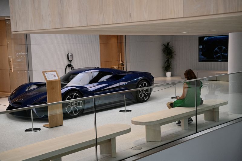 &copy; Reuters. FILE PHOTO: A woman sits near the sports car NIO EP9 at the NIO House, the showroom of the Chinese premium smart electric vehicle manufacture NIO Inc. in Berlin, Germany August 17, 2023. REUTERS/Annegret Hilse/File Photo