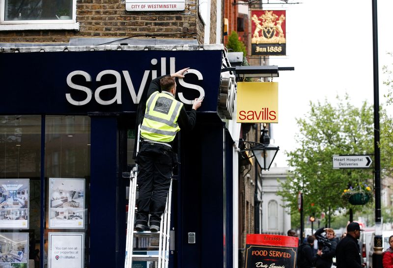 &copy; Reuters. FILE PHOTO: A worker puts up at Savills estate agents sign in London, Britain, April 10, 2018. REUTERS/Henry Nicholls/File Photo