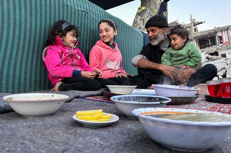 &copy; Reuters. عائلة فلسطينية تنتظر الإفطار وسط حطام منزلهم الذي تدمر جراء الغارات الإسرائيلية على قطاع غزة في بيت لاهيا بجنوب القطاع يوم الأربعاء. تصوير: 
