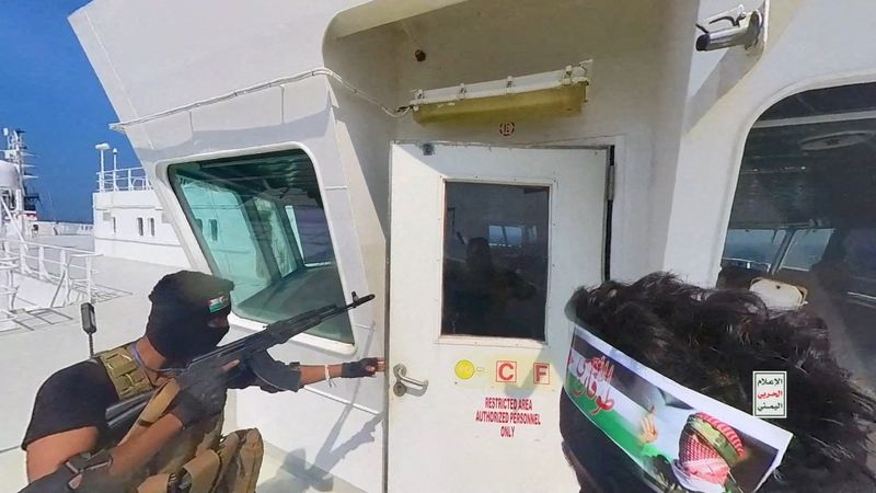 &copy; Reuters. FOTO DE ARCHIVO: Combatientes hutíes abren la puerta de la cabina en la cubierta del  buque de carga Galaxy Leader en el Mar Rojo en esta foto publicada el 20 de noviembre de 2023. Houthi Military Media/Handout via REUTERS/File Photo.