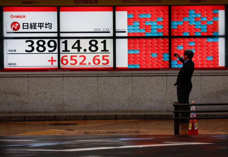 &copy; Reuters. رجل يلتقط صورة لشاشات إلكترونية تعرض بيانات المؤشر نيكي الياباني خارج شركة للوساطة المالية في طوكيو يوم 22 فبراير شباط 2024. تصوير: إيسي كاتو - 