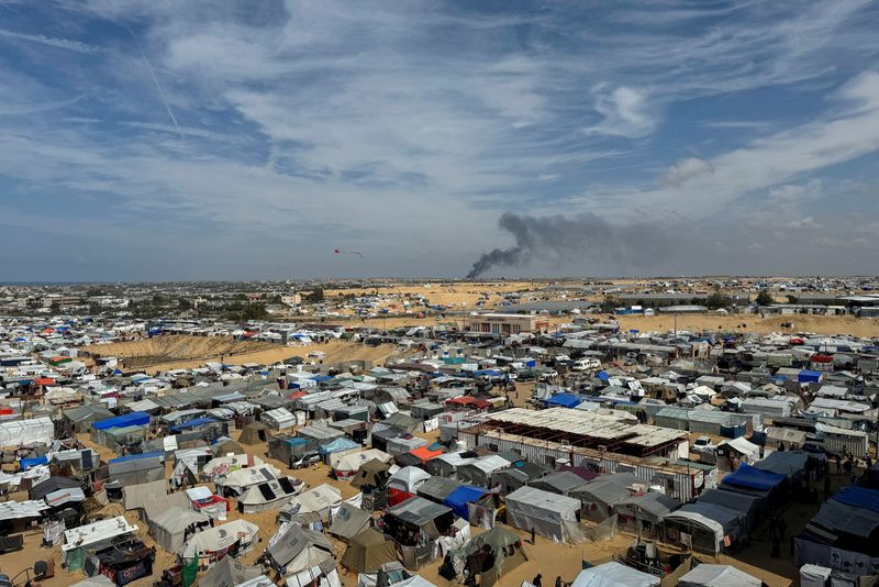 &copy; Reuters. De la fumée s'élève pendant une opération terrestre israélienne à Khan Younis, dans le cadre du conflit actuel entre Israël et le groupe islamiste palestinien Hamas, vue d'un camp de tentes abritant des Palestiniens déplacés à Rafah, dans le sud