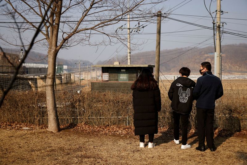&copy; Reuters. FILE PHOTO: A North Korean defector and his children stand in front of a barbed wire fence near the demilitarised zone separating the two Koreas, in Paju, February 12, 2021, on the occasion of Seolnal, the Korean Lunar New Year's day.   REUTERS/Kim Hong-J