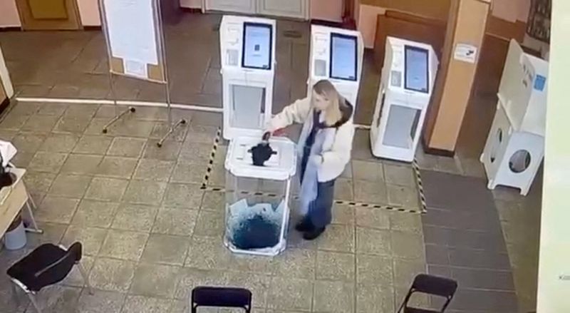 &copy; Reuters. Una mujer vierte un líquido en una urna electoral, durante las elecciones presidenciales rusas en Moscú, Rusia, en esta captura de pantalla tomada de una grabación de vídeo de una pantalla que muestra imágenes de circuito cerrado de televisión. 15 d