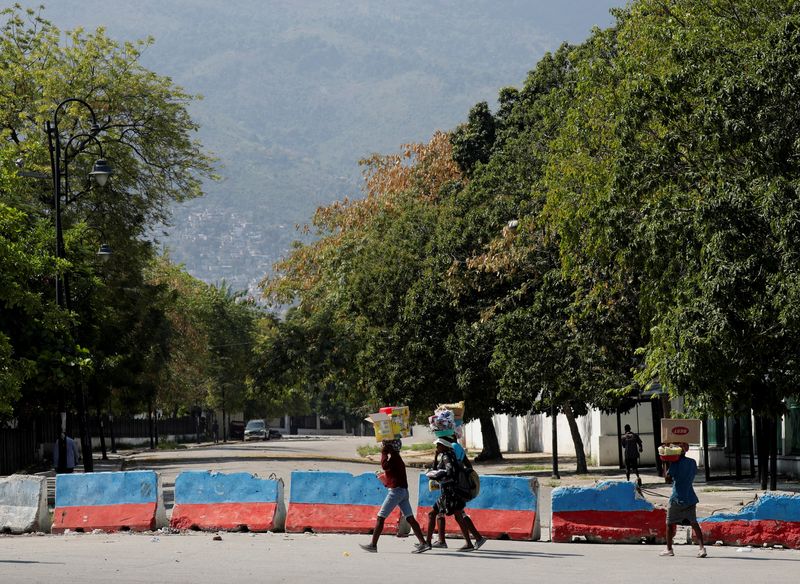 &copy; Reuters. FILE PHOTO: Street vendors carry goods for sale as they walk near the Presidential Palace after Haiti's Prime Minister Ariel Henry pledged to step down following months of escalating gang violence, in Port-au-Prince, Haiti March 12, 2024. REUTERS/Ralph Te
