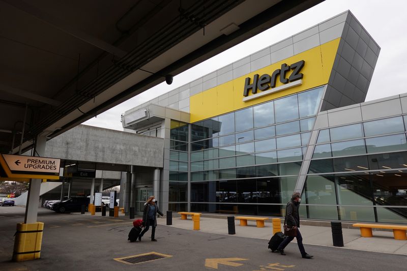 &copy; Reuters. FILE PHOTO: People walk by Hertz rental car signage at John F. Kennedy International Airport in Queens, New York City, U.S., March 30, 2022. REUTERS/Andrew Kelly/File Photo