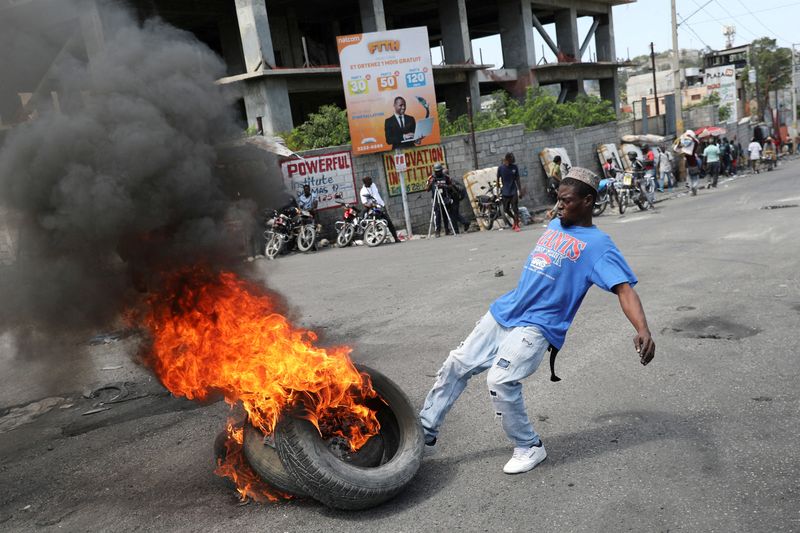&copy; Reuters. Un homme donne un coup de pied à des pneus en feu lors d'une manifestation antigouvernementale à Port-au-Prince, en Haïti. /Photo prise le 7 mars 2024/ REUTERS/Ralph Tedy