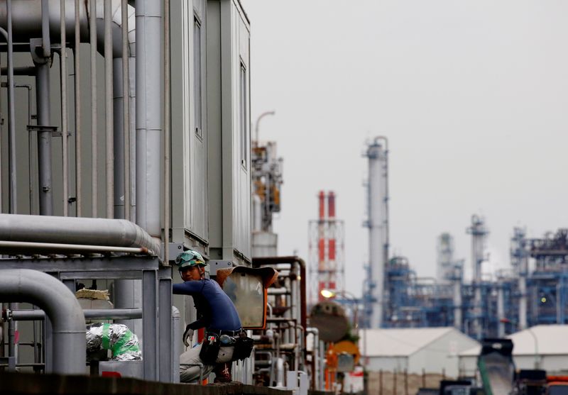 &copy; Reuters. FILE PHOTO: A worker is seen in front of facilities and chimneys of factories at the Keihin Industrial Zone in Kawasaki, Japan September 12, 2018. REUTERS/Kim Kyung-Hoon/File Photo