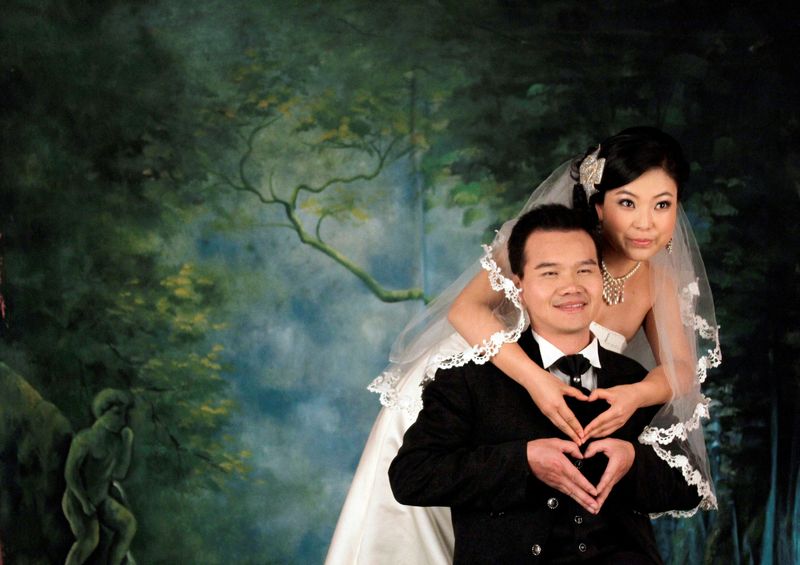 &copy; Reuters. FILE PHOTO: An engaged Chinese couple strike a pose for their wedding photographs at a studio in central Beijing November 27, 2009.  REUTERS/David Gray/File Photo