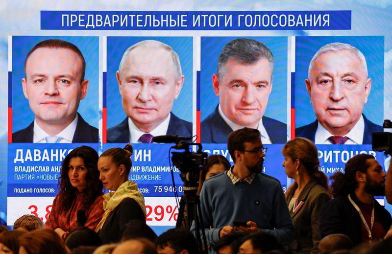 © Reuters. People gather near a screen showing results of Russia's election, March 18, 2024. REUTERS/Evgenia Novozhenina