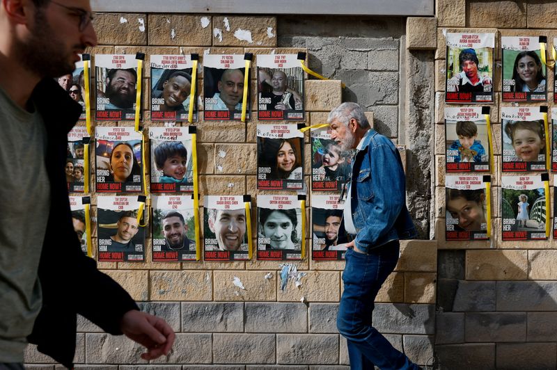 &copy; Reuters. FOTO DE ARCHIVO. Varias personas caminan junto a pancartas con fotos de los rehenes secuestrados en el ataque del 7 de octubre de Hamás contra Israel, en Tel Aviv, Israel. 17 de marzo 2024. REUTERS/Carlos García Rawlins