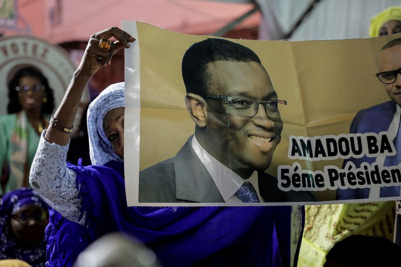 © Reuters. FILE PHOTO: A supporter of Senegalese presidential candidate Amadou Ba holds a poster during his campaign rally in Guediawaye on the outskirts of Dakar, Senegal March 10, 2024. REUTERS/Zohra Bensemra/File Photo