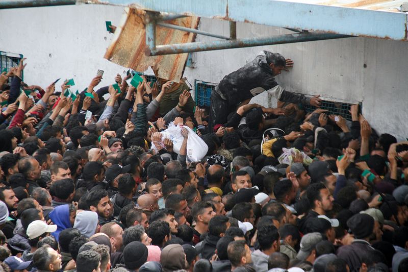 &copy; Reuters. Palestinos se reúnen para recibir ayuda en el exterior de un almacén de la UNRWA mientras los residentes de Gaza se enfrentan a niveles críticos de hambre, en medio del actual conflicto entre Israel y Hamás, en la ciudad de Gaza.
REUTERS/Mahmoud Issa