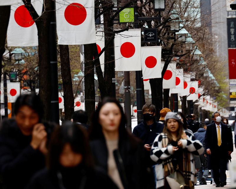 © Reuters. People walk past Japan’s national flags in a shopping district in Tokyo, Japan March 19, 2024. REUTERS/Kim Kyung-Hoon