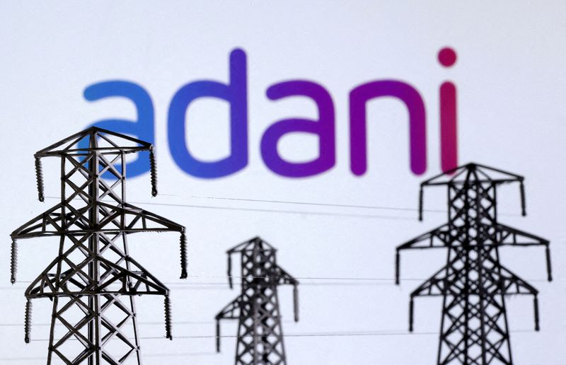 &copy; Reuters. Electric power transmission pylon miniatures and Adani Green Energy logo are seen in this illustration taken, December 9, 2022. REUTERS/Dado Ruvic/Illustration//File Photo