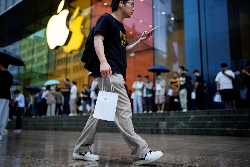 © Reuters. FILE PHOTO: A man holds a bag with a new iPhone inside it in Shanghai, China September 22, 2023. REUTERS/Aly Song/File Photo