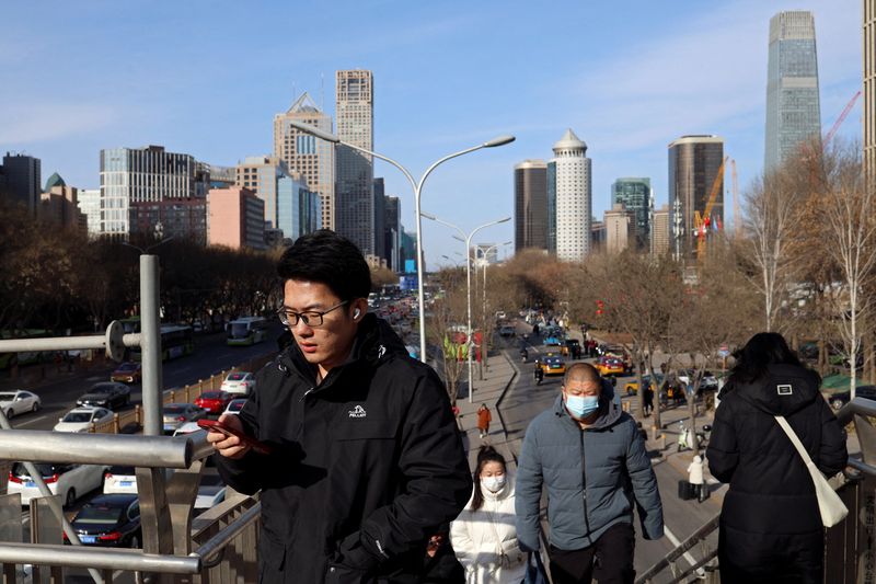 &copy; Reuters. FILE PHOTO: People walk on a pedestrian bridge at the central business district (CBD) during morning rush hour, ahead of the opening of the National People's Congress (NPC), in Beijing, China, February 29, 2024. REUTERS/Florence Lo/File Photo