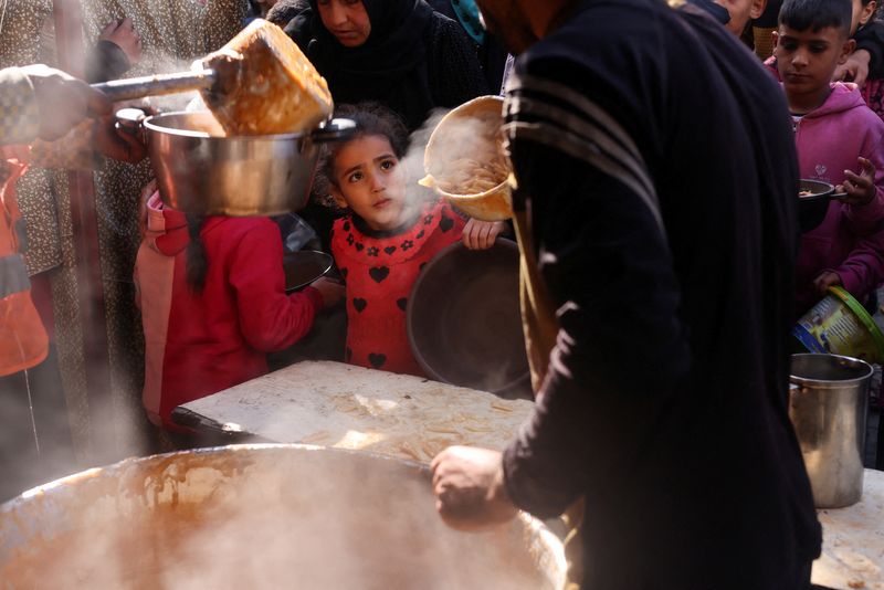 &copy; Reuters. Palestinians wait to receive food cooked by a charity kitchen amid shortages of food supplies, amid the ongoing conflict between Israel and the Palestinian Islamist group Hamas, in Rafah in the southern Gaza Strip, January 16, 2024. REUTERS/Saleh Salem/Fi