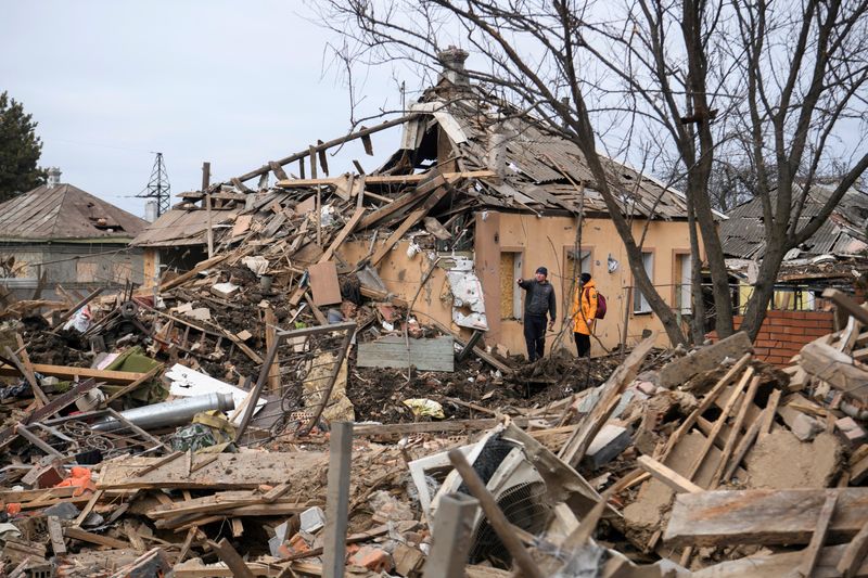&copy; Reuters. Local residents stand next to a building heavily damaged by a Russian missile strike, amid Russia's attack on Ukraine, in the town of Chuhuiv, Kharkiv region, Ukraine February 15, 2024. REUTERS/Vladyslav Musiienko/File Photo