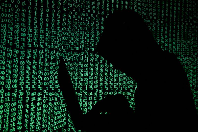 &copy; Reuters. A hooded man holds a laptop computer as cyber code is projected on him in this illustration picture taken on May 13, 2017. REUTERS/Kacper Pempel/Illustration/File Photo