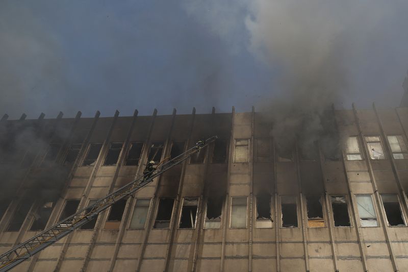 © Reuters. Firefighters work at a site of a printing house hit by a Russian missile strike, amid Russia's attack on Ukraine, in Kharkiv, Ukraine March 20, 2024. REUTERS/Sofiia Gatilova