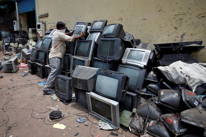 &copy; Reuters. تاجر أجهزة كهربائية مستعملة يكدس أجهزة تلفزيون قبل تفكيكها في مدينة أحمد اباد بالهند في صورة من أرشيف رويترز . 