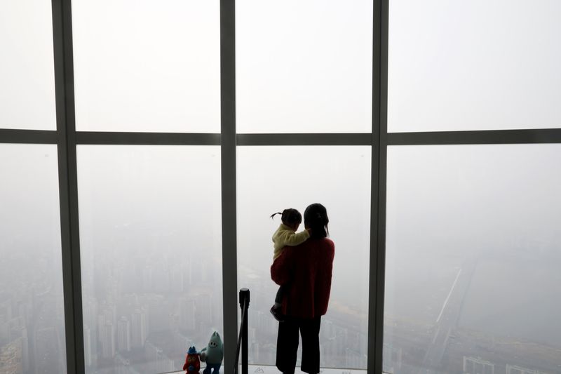 &copy; Reuters. A woman holding her baby in her arms looks at a view of Seoul shrouded by fine dust during a polluted day in Seoul, South Korea, March 6, 2019.    REUTERS/Kim Hong-Ji/FILE PHOTO