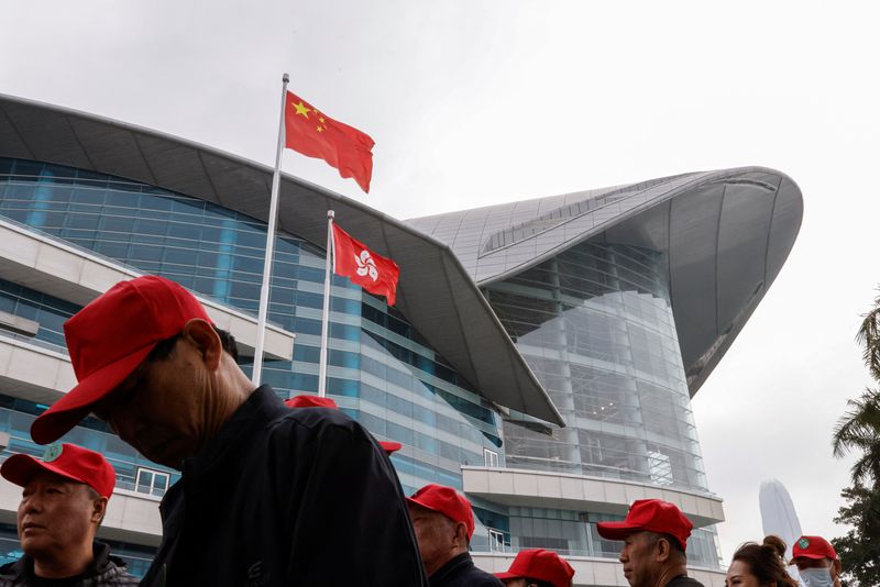 &copy; Reuters. FILE PHOTO: Chinese tourists walk in front of the Chinese and Hong Kong flags, outside the Convention and Exhibition Centre, in Hong Kong, China March 13, 2024. REUTERS/Tyrone Siu/File Photo