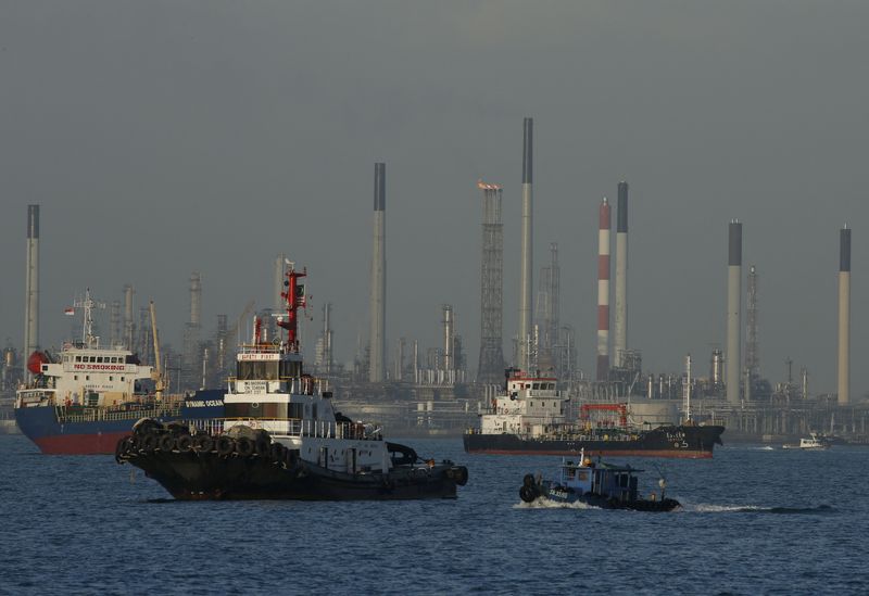 &copy; Reuters. 　３月２１日、アジア時間の原油先物は反発。米原油・ガソリン在庫の減少に支援されている。写真は石油精製所の前を通過する船舶。シンガポールで２０１６年２月撮影（２０２４　ロイ