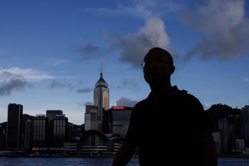 &copy; Reuters. A man walks along the waterfront in front of Victoria Harbour, with the iconic skyline buildings as a backdrop, in Hong Kong, China June 28, 2023. REUTERS/Tyrone Siu/File Photo