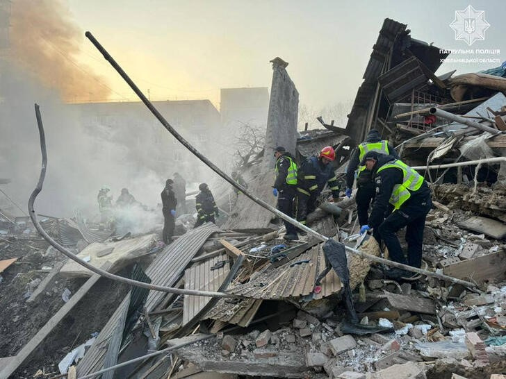 &copy; Reuters. عمال إنقاذ ورجال شرطة يعملون في موقع مباني سكنية متضررة جراء القصف الروسي على منطقة كميلنيتسكي بأوكرانيا يوم الجمعة. صورة لرويترز من الخدمة
