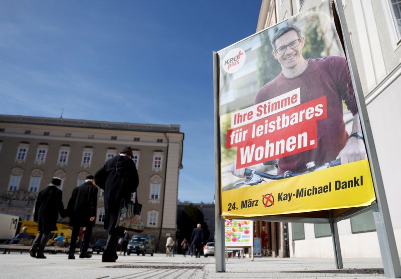 © Reuters. People walk past an election campaign poster of Communist Plus party candidate Kay-Michael Dankl in Salzburg, Austria, March 20, 2024. REUTERS/Leonhard Foeger