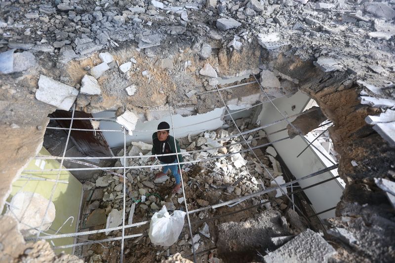 &copy; Reuters. Un palestinese ispeziona il luogo di un attacco israeliano a una casa, nel corso del conflitto in corso tra Israele e Hamas, a Khan Younis, nel sud della Striscia di Gaza, il 22 marzo 2024. REUTERS/Ahmed Zakot