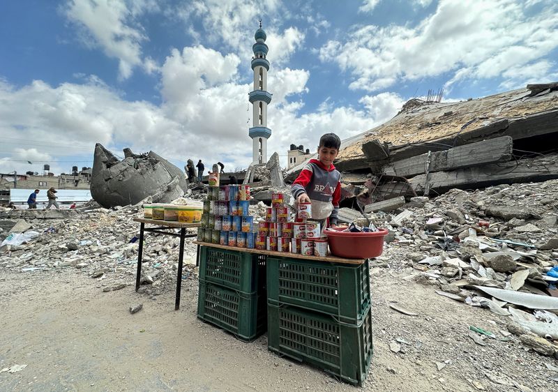 &copy; Reuters. A boy stands next to canned food on the day of Friday prayers during the holy fasting month of Ramadan, amid the ongoing conflict between Israel and the Palestinian Islamist group Hamas, in Rafah, in the southern Gaza Strip, March 22, 2024. REUTERS/Mohamm