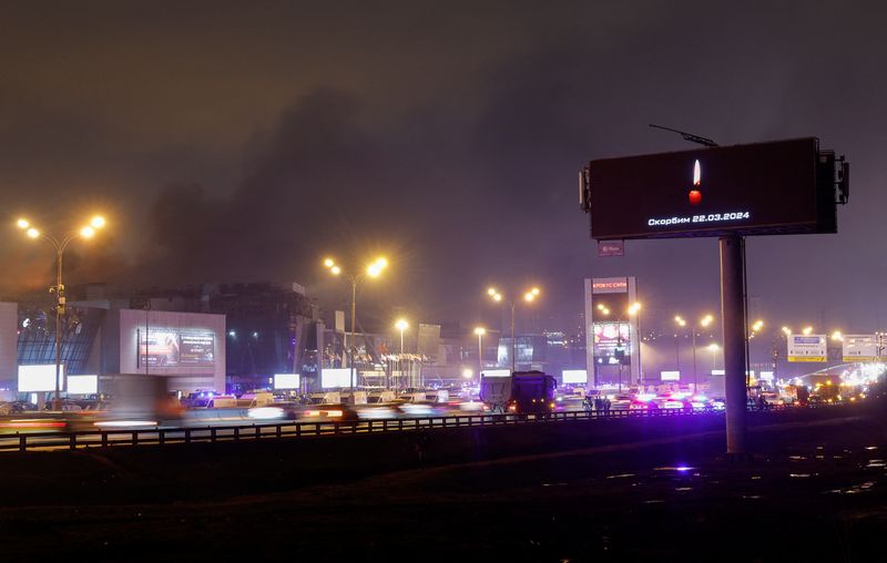 &copy; Reuters. A digital board with a date and a slogan, that reads "We mourn" displayed in memory of victims of the shooting incident, is seen opposite the burning Crocus City Hall concert venue on the outskirts of Moscow, Russia, March 23, 2024. REUTERS/Maxim Shemetov