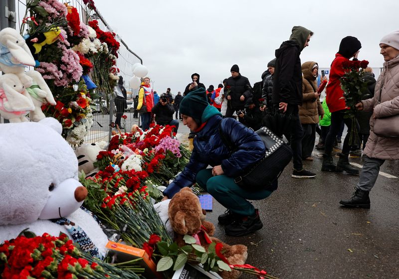 &copy; Reuters. People lay flowers at a makeshift memorial to the victims of a shooting attack at the Crocus City Hall concert venue in the Moscow Region, Russia, March 23, 2024. REUTERS/Yulia Morozova