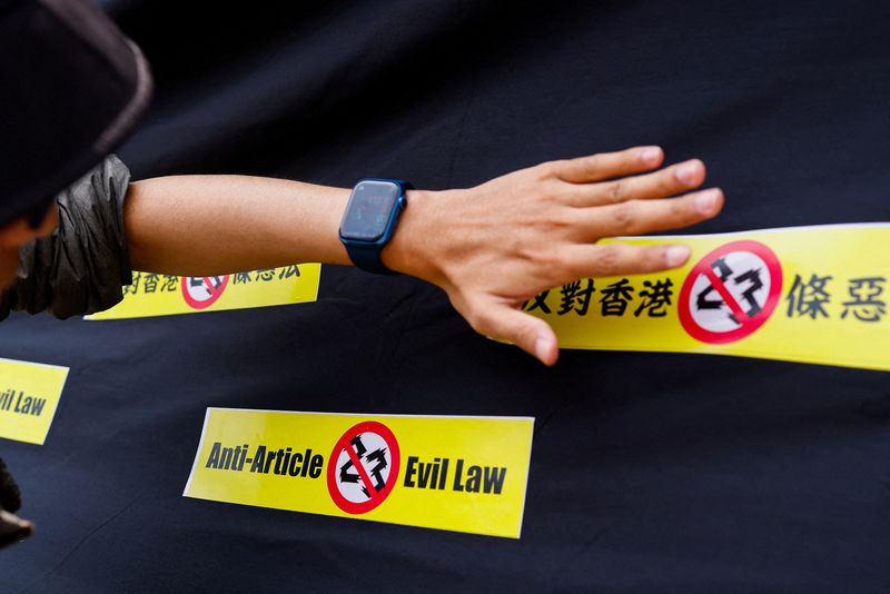 &copy; Reuters. Un voluntario coloca una pegatina contra la ley de seguridad nacional Artículo 23 de Hong Kong durante una protesta en Taipéi, Taiwán. 23 marzo 2023. REUTERS/Ann Wang