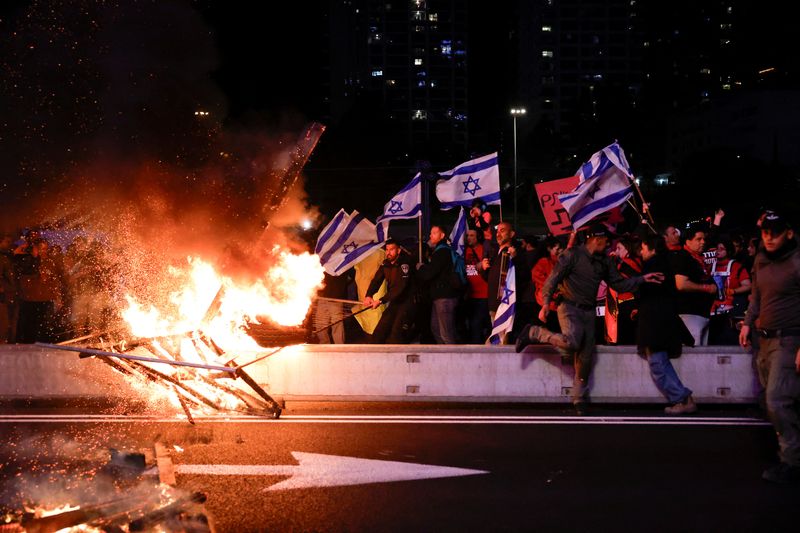 &copy; Reuters. Police officers try to move a burning barricade during a protest against Israeli Prime Minister Benjamin Netanyahu's government and call for the release of hostages kidnapped in the deadly October 7 attack on Israel by the Palestinian Islamist group Hamas