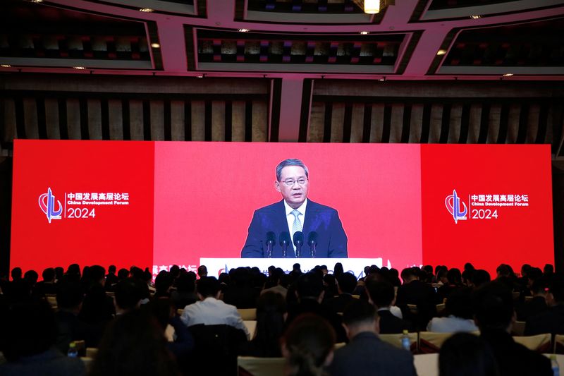 &copy; Reuters. Journalists watch a giant screen showing live-streaming footage of Chinese Premier Li Qiang delivering a speech at the opening ceremony of China Development Forum (CDF) 2024, in Beijing, China March 24, 2024. REUTERS/Jing Xu