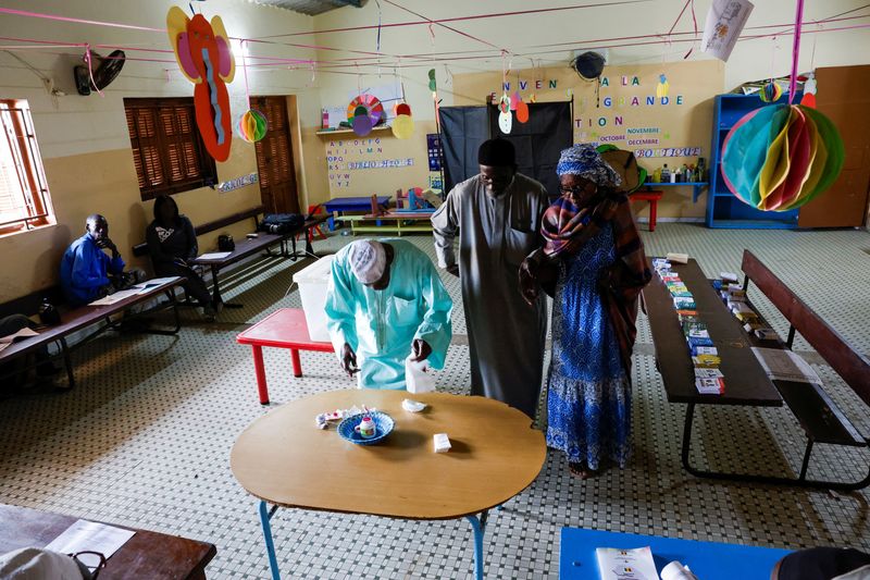 &copy; Reuters. Voters prepare to cast their vote during the presidential election at the polling station at Ecole HLM Grand Medine in Dakar, Senegal, March 24, 2024. REUTERS/Luc Gnago