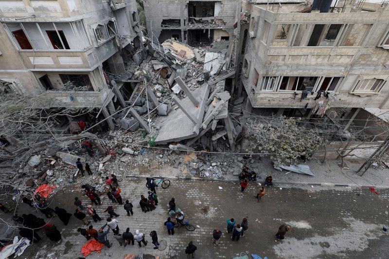 &copy; Reuters. فلسطينيون يتفقدون موقع منزل تدمر جراء غارة إسرائيلية في رفح بجنوب قطاع غزة يوم الأحد. تصوير: محمد سالم - رويترز