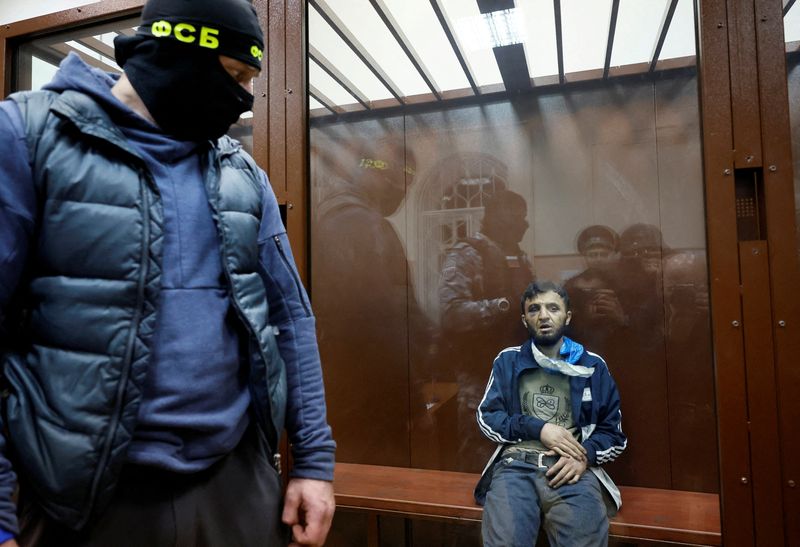 © Reuters. Dalerdzhon Mirzoyev, a suspect in the shooting attack at the Crocus City Hall concert venue, sits behind a glass wall of an enclosure for defendants at the Basmanny district court in Moscow, Russia March 24, 2024. REUTERS/Shamil Zhumatov