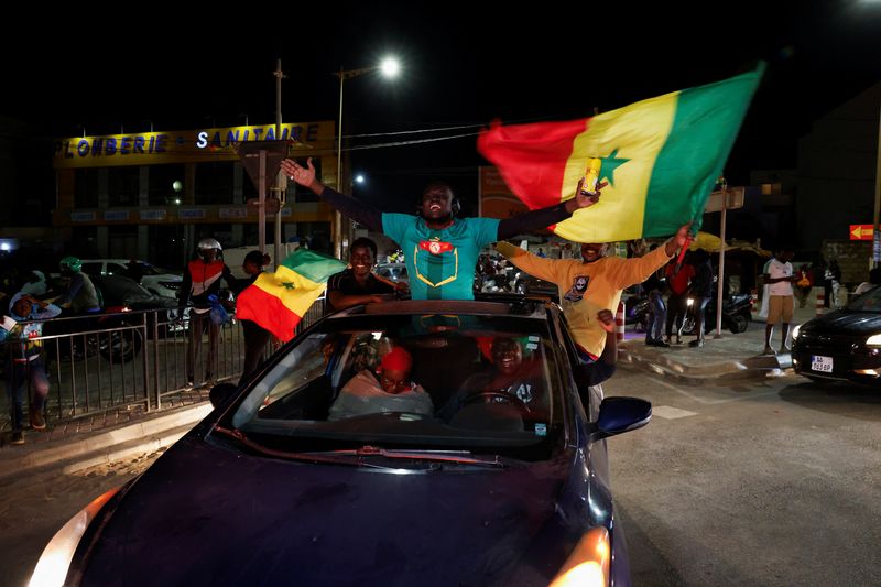 © Reuters. Photo des des partisans du candidat présidentiel sénégalais Bassirou Diomaye Faye qui célèbrent les premiers résultats de l'élection présidentielle. /Photo prise le 24 mars 2024 à Dakar, Senegal/REUTERS/Luc Gnago