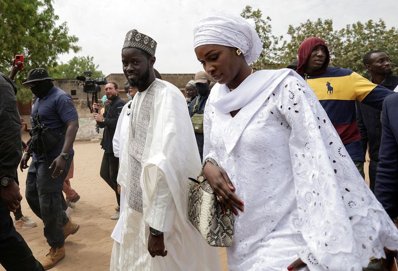 &copy; Reuters. Presidential candidate Bassirou Diomaye Faye, who is backed by Senegalese opposition leader Ousmane Sonko, walks with one of his wives after casting his vote at the polling station at Ndiaganiao in Mbour, Senegal March 24, 2024. REUTERS/Zohra Bensemra/ Fi